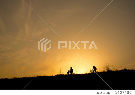 土手 夕方 夕焼け 帰り道の写真素材