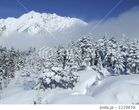 雪山 吹雪の晴れ間 雪の北アルプス 吹雪の穂高岳の写真素材