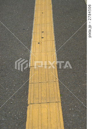 歩道 誘導ブロック 交差点 視覚障害 障害者 盲人 黄色 タイル 点字ブロックの写真素材