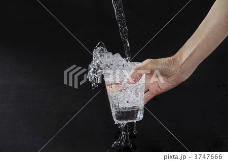 水 こぼれる 手 グラスの写真素材