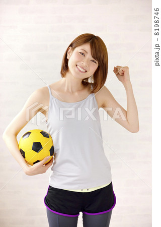 サッカーボールを持つスポーツウェアの女性の写真素材
