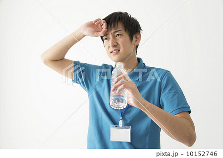 汗 拭う 水分補給 男性の写真素材