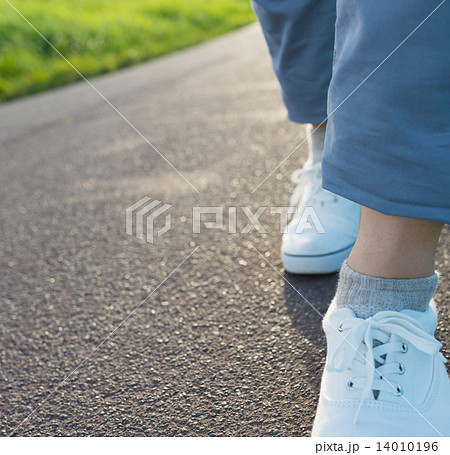 スニーカー 歩く 舗装路 ボディーパーツの写真素材