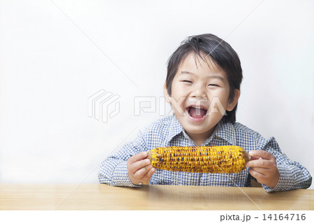 焼きとうもろこし 男の子 子供 食べるの写真素材