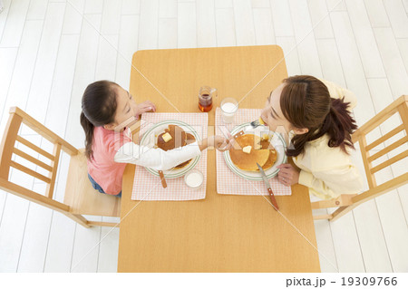 親子 食べさせる パンケーキ 娘の写真素材