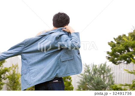 男性 ジャケット 着る 後ろ姿の写真素材