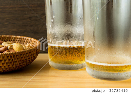 ビール 飲み残し ミックスナッツ グラスの写真素材