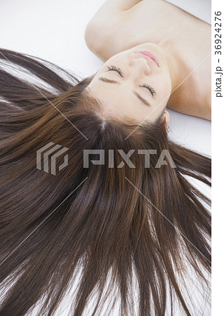 女性 寝る 眠る 仰向け 笑顔 かわいい 屋内 代 長髪の写真素材