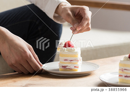 男性 食べる ケーキ 顔の写真素材