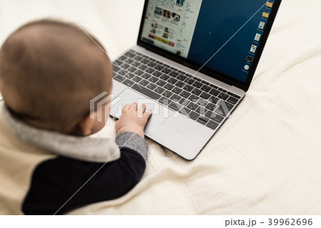 赤ちゃん ノートパソコン 興味 触るの写真素材