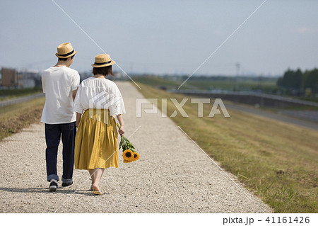 後姿 麦わら帽子 女の子 向日葵の写真素材