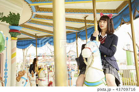女子高生 遊園地 遊ぶ メリーゴーランドの写真素材