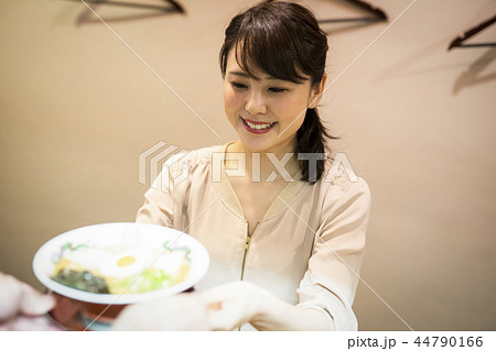 女性 一人 ラーメン 受け取るの写真素材