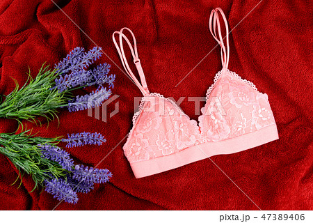 woman pink lace bra, panties lingerie near pampas grass on black