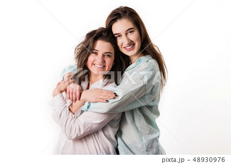 Diverse young girls in sportswear hugging after outdoor yoga class