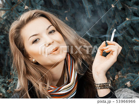 茶髪 女の子 若い タバコの写真素材