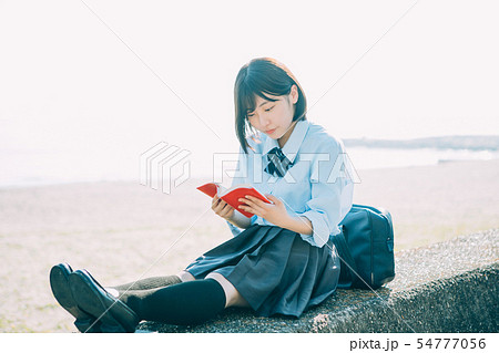 女子高生 海 制服 ポートレートの写真素材