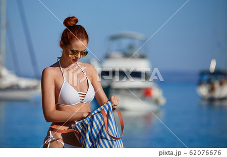 A woman in a trendy bikini lounging on a beach towel. Generative