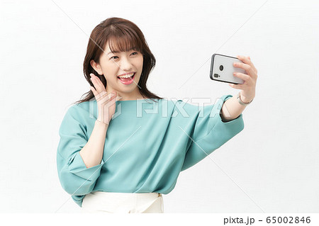 女性 スマートフォン 自撮り ポーズの写真素材