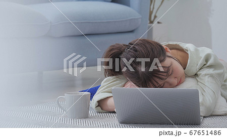 女性 パソコン ノートパソコン 寝るの写真素材
