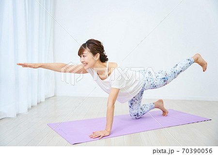 Adult Fit Woman Practice Pilates with Props in Fitness Studio