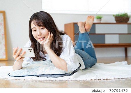 くつろぐ 女性 寝転がる 頬杖の写真素材