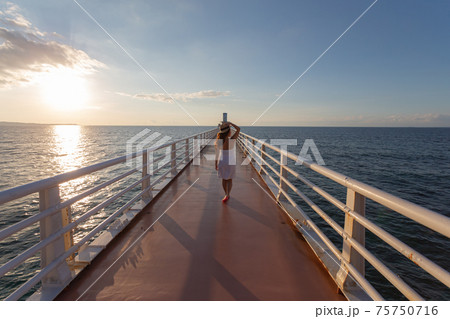 女の子 海 後ろ姿 夕暮れの写真素材