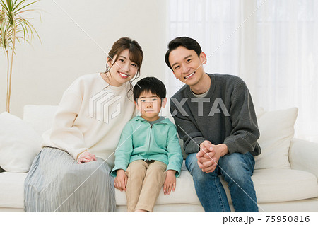 スマイル 座る 正面 ソファーの写真素材