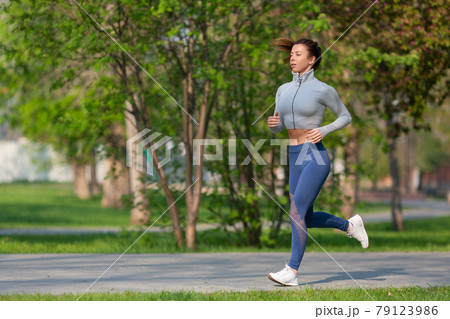 Photo of a Woman Running in Park in Early Morning. Attractive