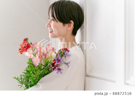 女性 花束 抱える 花の写真素材