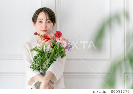 女性 花束 抱える 花の写真素材