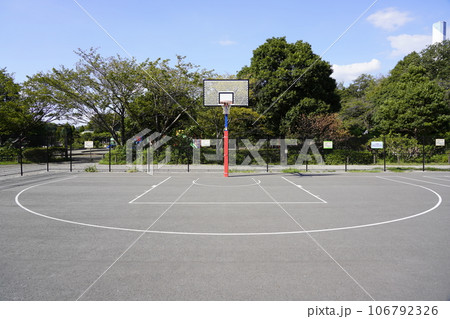 Outdoor Basketball Court with Homes and Mountain Against Overcast